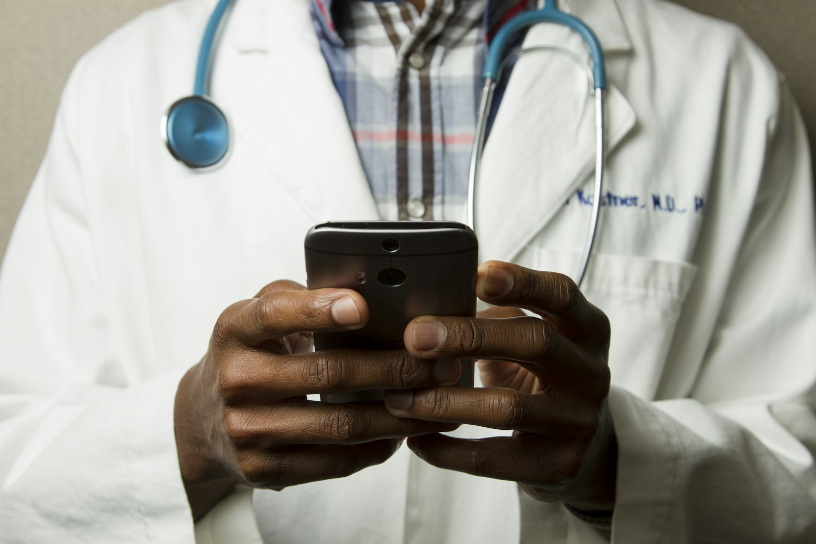 Profesional de clínica usando el celular para gestionar citas y recordatorios automáticos